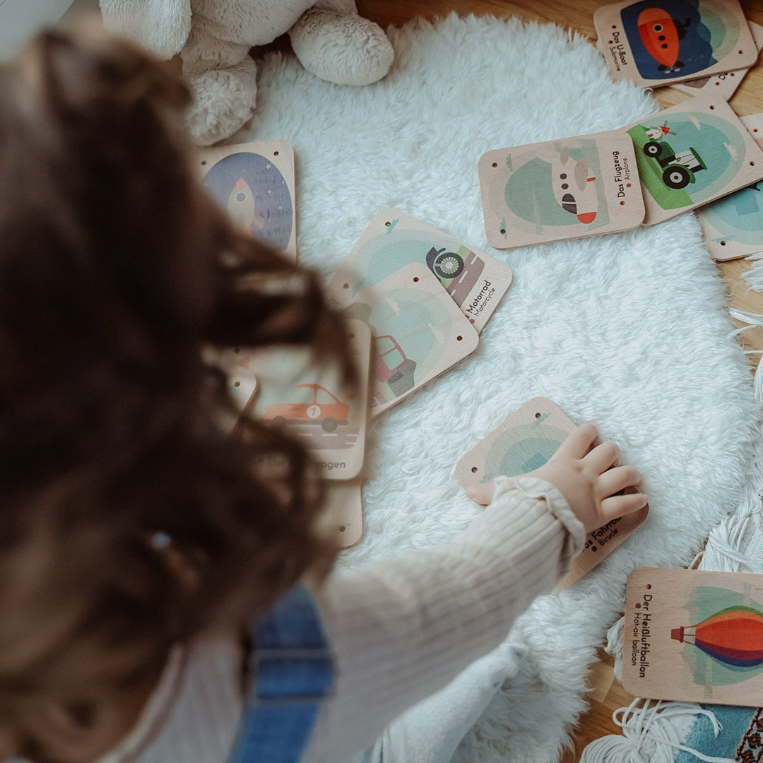 Kind spielt mit Fahrzeugkarten