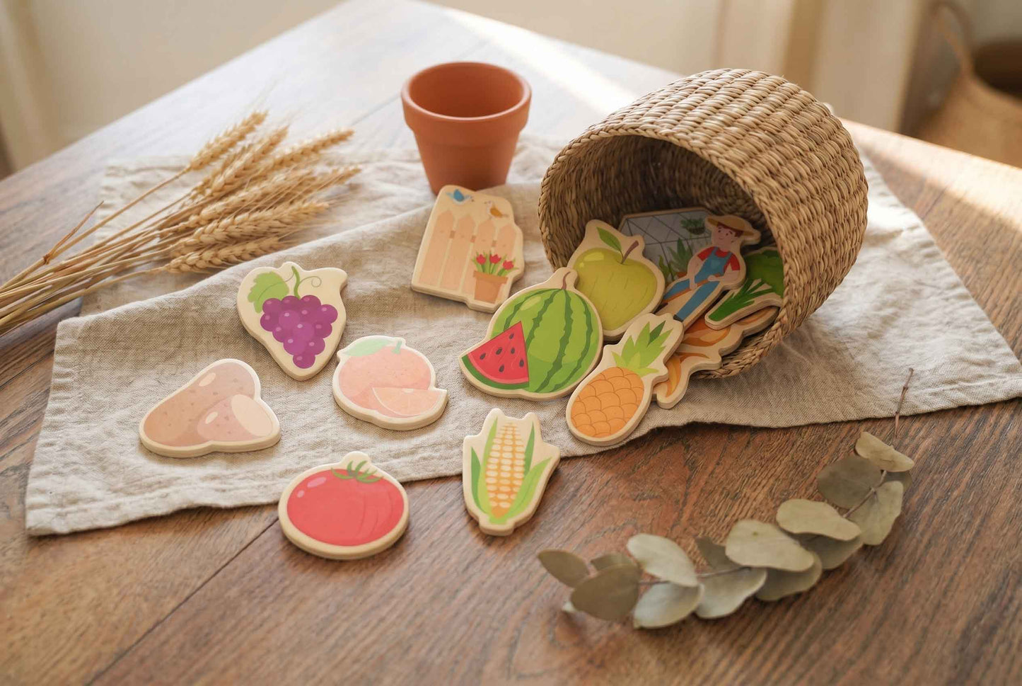 Bunte Obst- und Gemüse Holzmagnete auf einem Tisch mit natürlicher Dekoration arrangiert