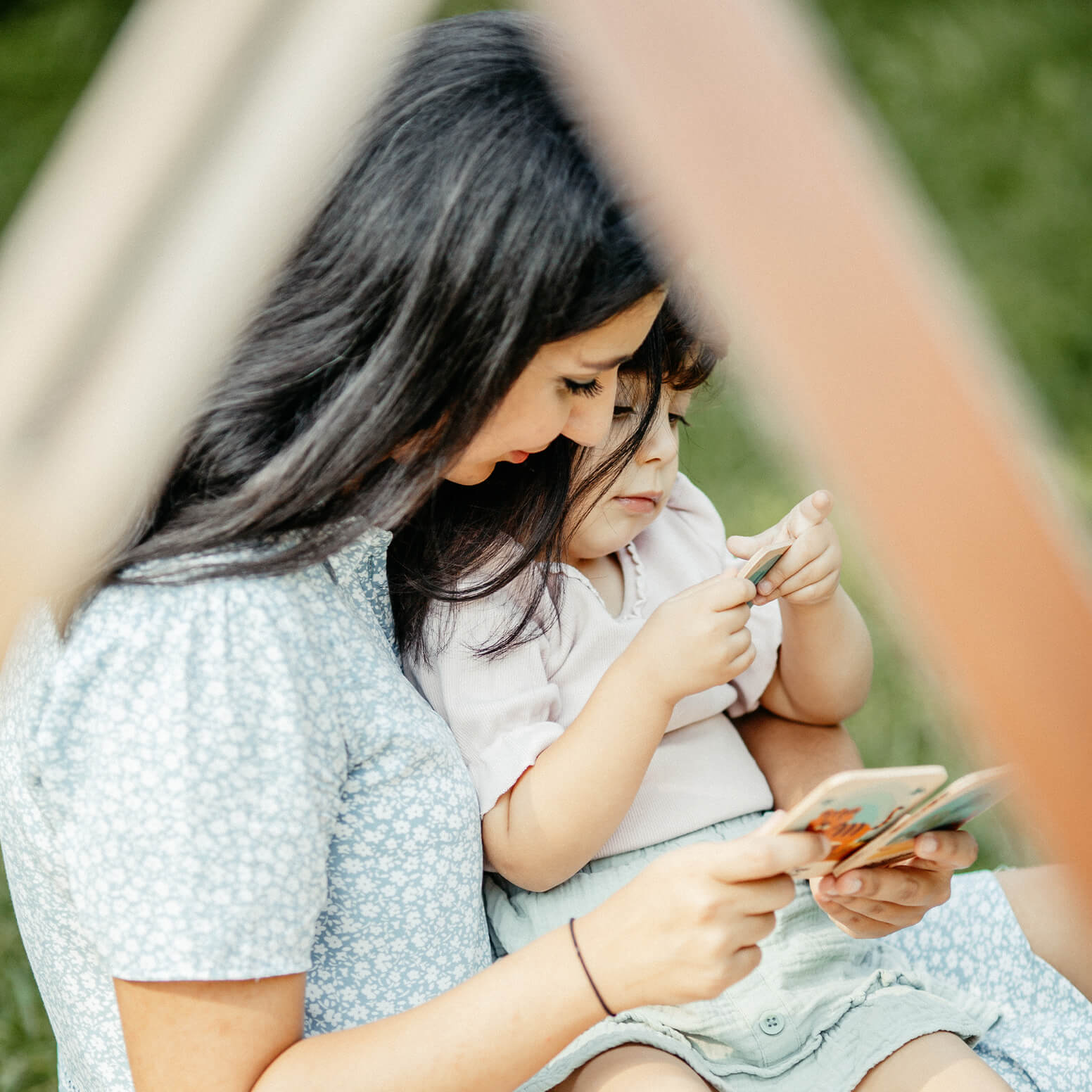 Mama und Tochter schauen sich Montessori Lernkarten aus Holz mit Tier Motiven an