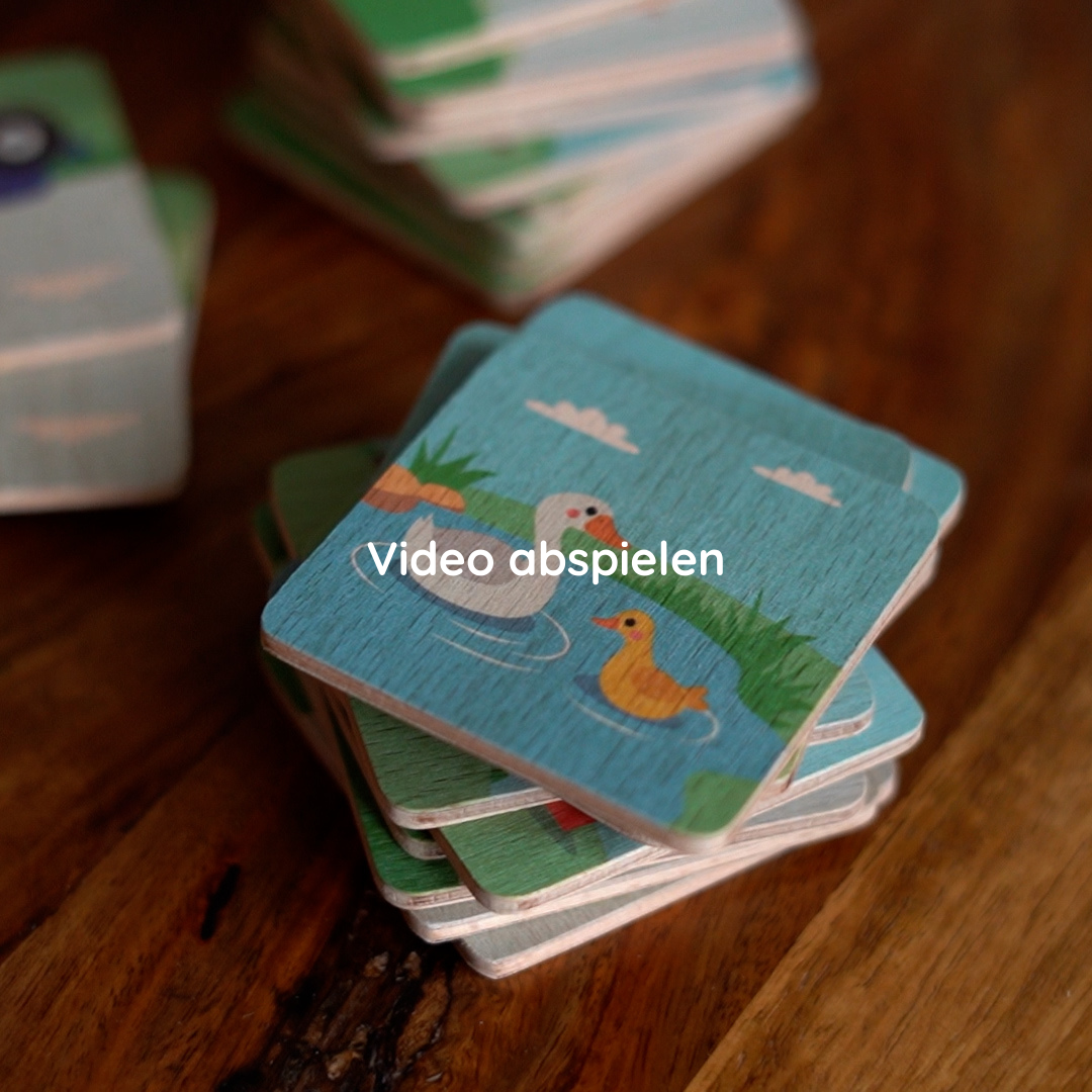 Kind spielt mit Memorykarten aus Holz